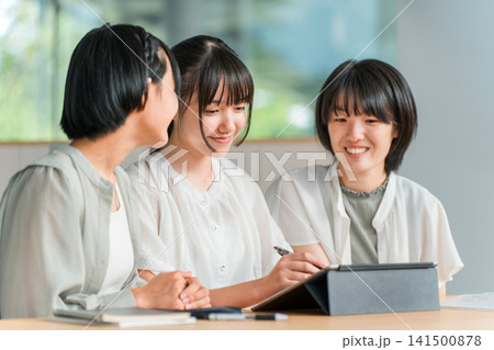 タブレットを使いながら勉強する私服姿の小学生,中学生の女の子(宿題,塾) タブレットを使いながら勉強する私服姿の小学生,中学生の女の子(宿題,塾) 141500878