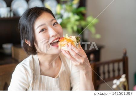 古民家風民泊でサンドイッチを食べる若い女性 古民家風民泊でサンドイッチを食べる若い女性 141501397