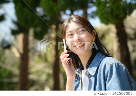 公園で通話する日本人女性 公園で通話する日本人女性 141502003
