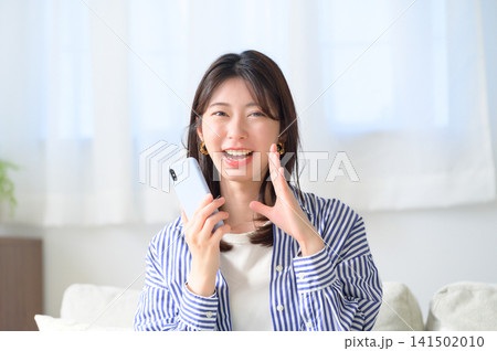 スマートフォンを持って呼びかける日本人女性 スマートフォンを持って呼びかける日本人女性 141502010