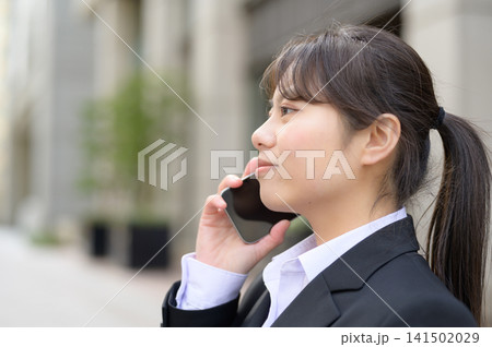 スマートフォンで通話する20代日本人女性会社員 スマートフォンで通話する20代日本人女性会社員 141502029