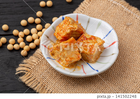 fermented bean curd in spicy chili oil, traditional Chinese sufu or chaozhou tofu on a white plate, gourmet Asian snack. fermented bean curd in spicy chili oil, traditional Chinese sufu or chaozhou tofu on a white plate, gourmet Asian snack. 141502248