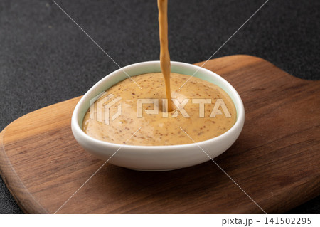 creamy roasted sesame salad dressing, nutty savory sauce condiment for Asian fusion cuisine and dipping. 141502295