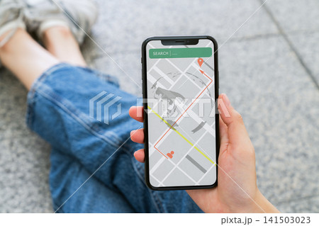Woman using smartphone with map application for navigation and location tracking. 141503023