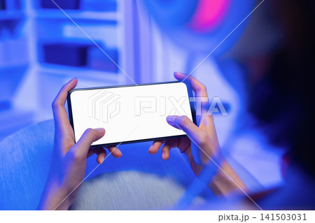 Hands holding smartphone with blank screen while playing mobile game. 141503031