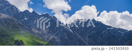 Panorama of sharp Caucasus ridge under blue cloudy sky with copy space Panorama of sharp Caucasus ridge under blue cloudy sky with copy space 141503930
