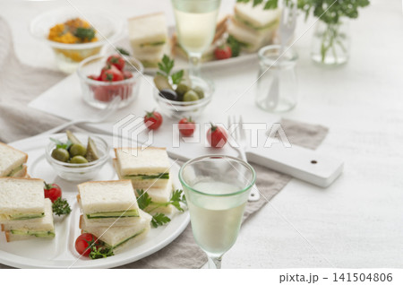 ワインとともに楽しむキュウリのサンドイッチと軽食のテーブルコーディネート ワインとともに楽しむキュウリのサンドイッチと軽食のテーブルコーディネート 141504806