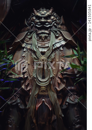 Elaborate bronze armor and ornate detailing of Wei Tuo Bodhisattva statue at Luohan Temple in Chongqing, China. The image highlights the powerful Chinese Buddhist guardian's protective armor, artistic 141505841