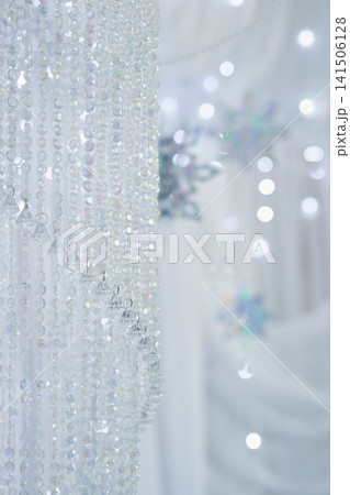Sparkling Crystal Beaded Curtain and Blurred Snowflakes on White Sparkling Crystal Beaded Curtain and Blurred Snowflakes on White 141506128
