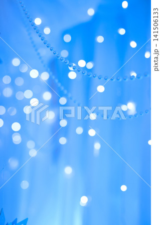 Hanging Metallic Snowflakes and Draped Beads on Blue Bokeh Background 141506133