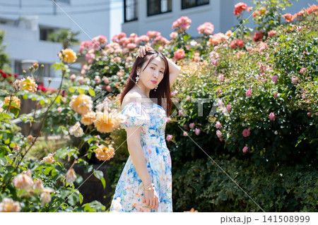 薔薇の花の前でポーズを取る女性 薔薇の花の前でポーズを取る女性 141508999