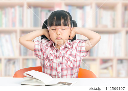 Stressed school girl feeling overwhelmed by homework and books, education pressure concept 141509107
