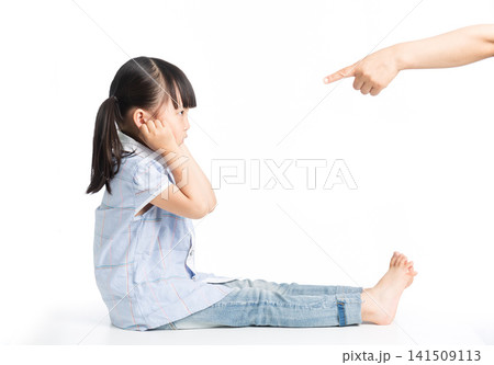 Hand pointing at sad little girl covering ears for discipline concept Hand pointing at sad little girl covering ears for discipline concept 141509113