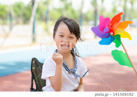 Energetic young girl sitting outdoors and showing a fist gesture of determination or success. 141509192