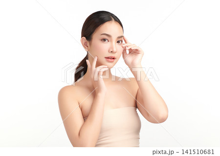 A beautiful young Asian woman with clean, fresh skin against a white background. Skincare, facial treatment, cosmetology, beauty, and spa. An elegant portrait of an Asian woman. 141510681