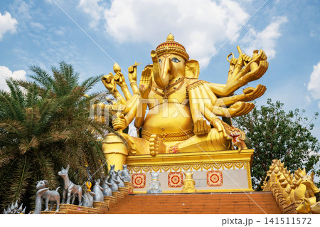 Gold ganecha statue with thousand hands against blue sky Gold ganecha statue with thousand hands against blue sky 141511572