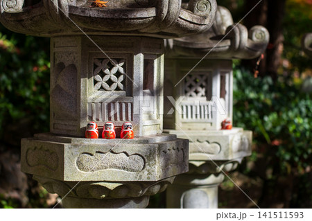 Daruma dolls on lantern in fall garden of Katsuo-ji temple, Osaka Daruma dolls on lantern in fall garden of Katsuo-ji temple, Osaka 141511593