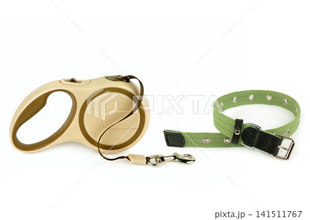 Retractable dog leash and green collar isolated on white background. Pet accessories set with extendable lead and fabric collar on white. Retractable dog leash and green collar isolated on white background. Pet accessories set with extendable lead and fabric collar on white. 141511767