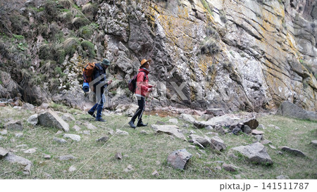 A group of two men are trekking in the mountains. A group of friends actively spends time in nature. Weekend camping trip A group of two men are trekking in the mountains. A group of friends actively spends time in nature. Weekend camping trip 141511787