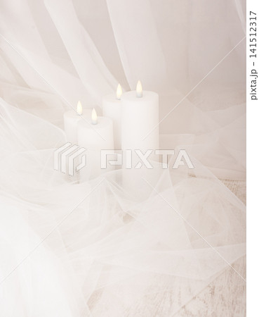 Four white wax candles in delicate white tulle and veil 141512317