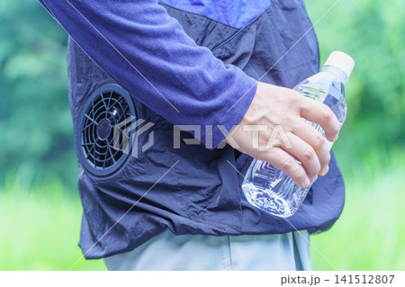 熱中症対策|ファン付きウェアを着でペットボトルの水を持つ男性 熱中症対策|ファン付きウェアを着でペットボトルの水を持つ男性 141512807