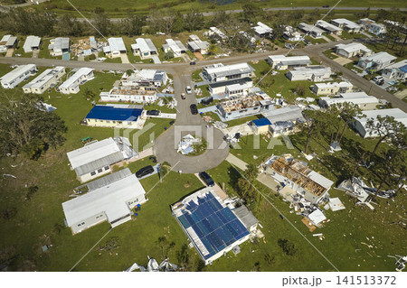 Severely damaged houses after hurricane Ian in Florida mobile home residential area. Consequences of natural disaster 141513372
