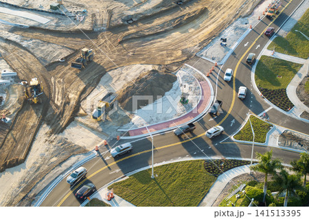Roadworks construction site at roundabout intersection on American highway. Development of city circular transportation crossroads Roadworks construction site at roundabout intersection on American highway. Development of city circular transportation crossroads 141513395