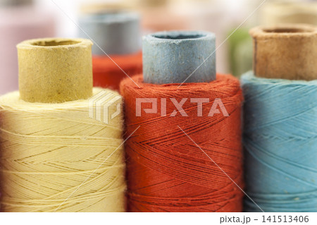 Reels or spools of multicolored sewing threads. Threads of all colors. Shallow depth of field. Close-up macro shot. Reels or spools of multicolored sewing threads. Threads of all colors. Shallow depth of field. Close-up macro shot. 141513406
