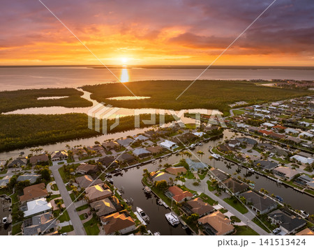 Punta Gorda, Florida at evening hour. Waterfront suburban houses and palm trees shine in warm tropical sunset atmosphere. Punta Gorda, Florida at evening hour. Waterfront suburban houses and palm trees shine in warm tropical sunset atmosphere. 141513424