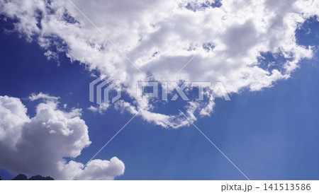Bright daytime photograph of white fluffy cumulus clouds against a vibrant blue sky, sky scape concept. Bright daytime photograph of white fluffy cumulus clouds against a vibrant blue sky, sky scape concept. 141513586