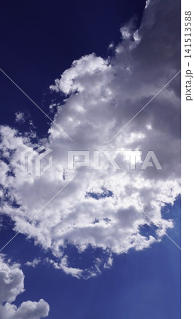 Dramatic photograph of white fluffy cumulus clouds against a deep navy blue sky, ethereal concept. Dramatic photograph of white fluffy cumulus clouds against a deep navy blue sky, ethereal concept. 141513588