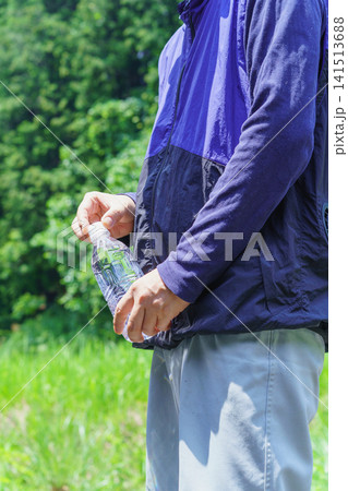 熱中症対策|炎天下でペットボトルの水を持つ男性 熱中症対策|炎天下でペットボトルの水を持つ男性 141513688