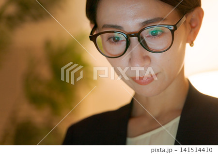 遅くまで仕事をする女性 遅くまで仕事をする女性 141514410