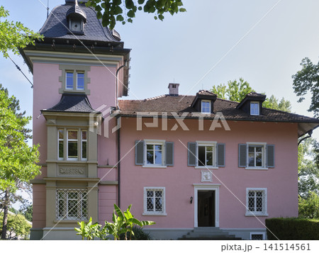 Historic house with pink walls surrounded by green trees in a park Historic house with pink walls surrounded by green trees in a park 141514561