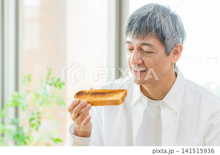食パンを食べるシニア男性 食パンを食べるシニア男性 141515936