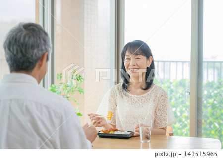 シニア夫婦に食事をする女性 シニア夫婦に食事をする女性 141515965