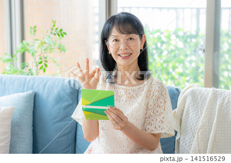 通帳を持つシニア女性 通帳を持つシニア女性 141516529