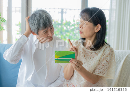 通帳を見て悩むシニア夫婦 通帳を見て悩むシニア夫婦 141516536