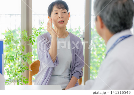 診察を受けるシニア女性と医者 診察を受けるシニア女性と医者 141516549