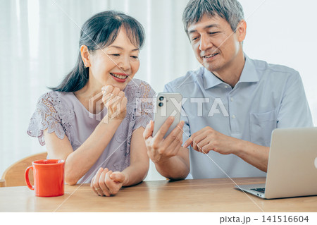 スマホを見るシニア夫婦 スマホを見るシニア夫婦 141516604