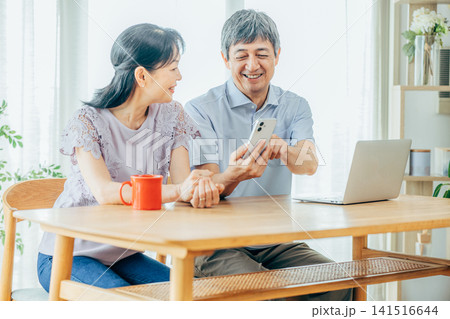スマホを見るシニア夫婦 141516644