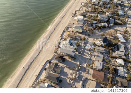 Storm surge severe damage to residential houses on ocean shore after hurricane landfall. Natural disaster consequences in Florida Storm surge severe damage to residential houses on ocean shore after hurricane landfall. Natural disaster consequences in Florida 141517305