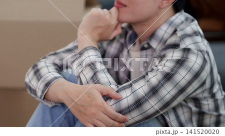 Young Asian man sitting stressed and anxious amid moving boxes in empty apartment during home relocation Young Asian man sitting stressed and anxious amid moving boxes in empty apartment during home relocation 141520020