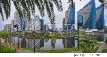 Modern skyscrapers skyline reflected in lake water with palm trees in Batumi Georgia with copy space 141520792
