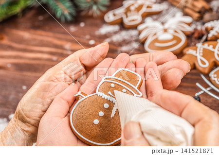 Decorating Gingerbread Snowman Cookie with Royal Icing 141521871