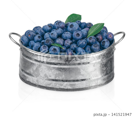 Fresh Blueberries with Green Leaves in Rustic Metal Bowl Isolated on White 141521947