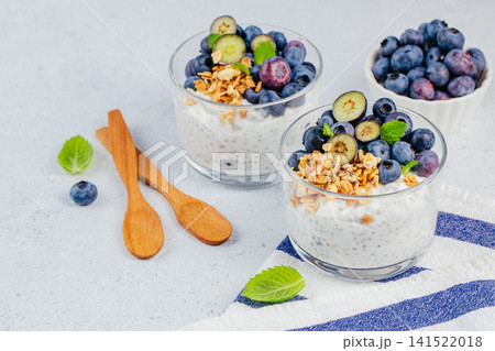 Blueberry chia yogurt parfait with granola and fresh berries in glasses Blueberry chia yogurt parfait with granola and fresh berries in glasses 141522018