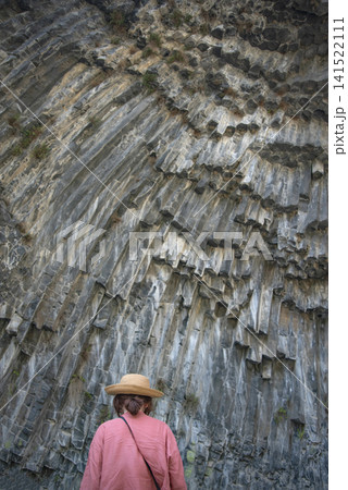 Woman tourist in straw hat looking at Symphony of Stones basalt columns in Garni Armenia with copy space Woman tourist in straw hat looking at Symphony of Stones basalt columns in Garni Armenia with copy space 141522111