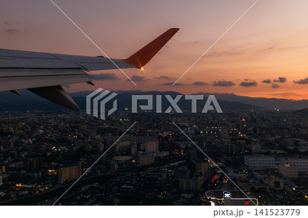 夕暮れ時の空港と機窓から望む美しい夕焼け空と街並み 141523779