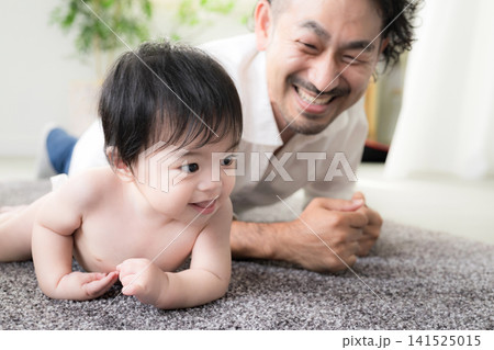 ハイハイする赤ちゃんを見守る父親 育児・子育て・成長・親子のふれあいのイクメン育休パパと赤ちゃんのイ ハイハイする赤ちゃんを見守る父親 育児・子育て・成長・親子のふれあいのイクメン育休パパと赤ちゃんのイ 141525015
